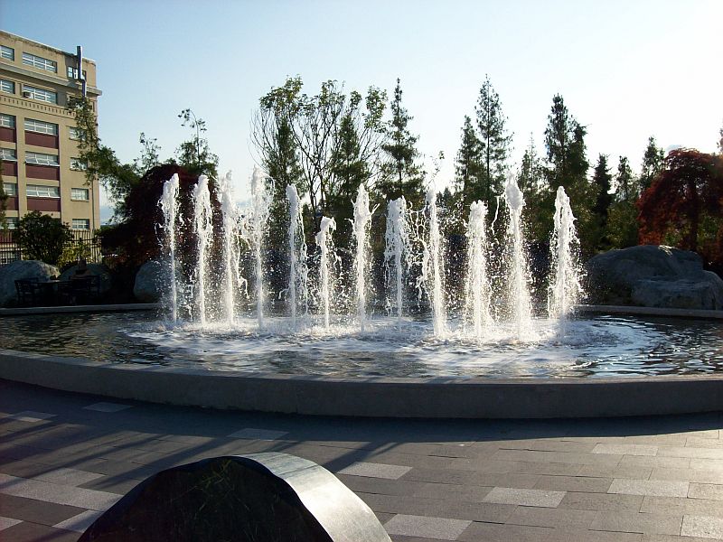 the fountain has several jets on it as well as two people