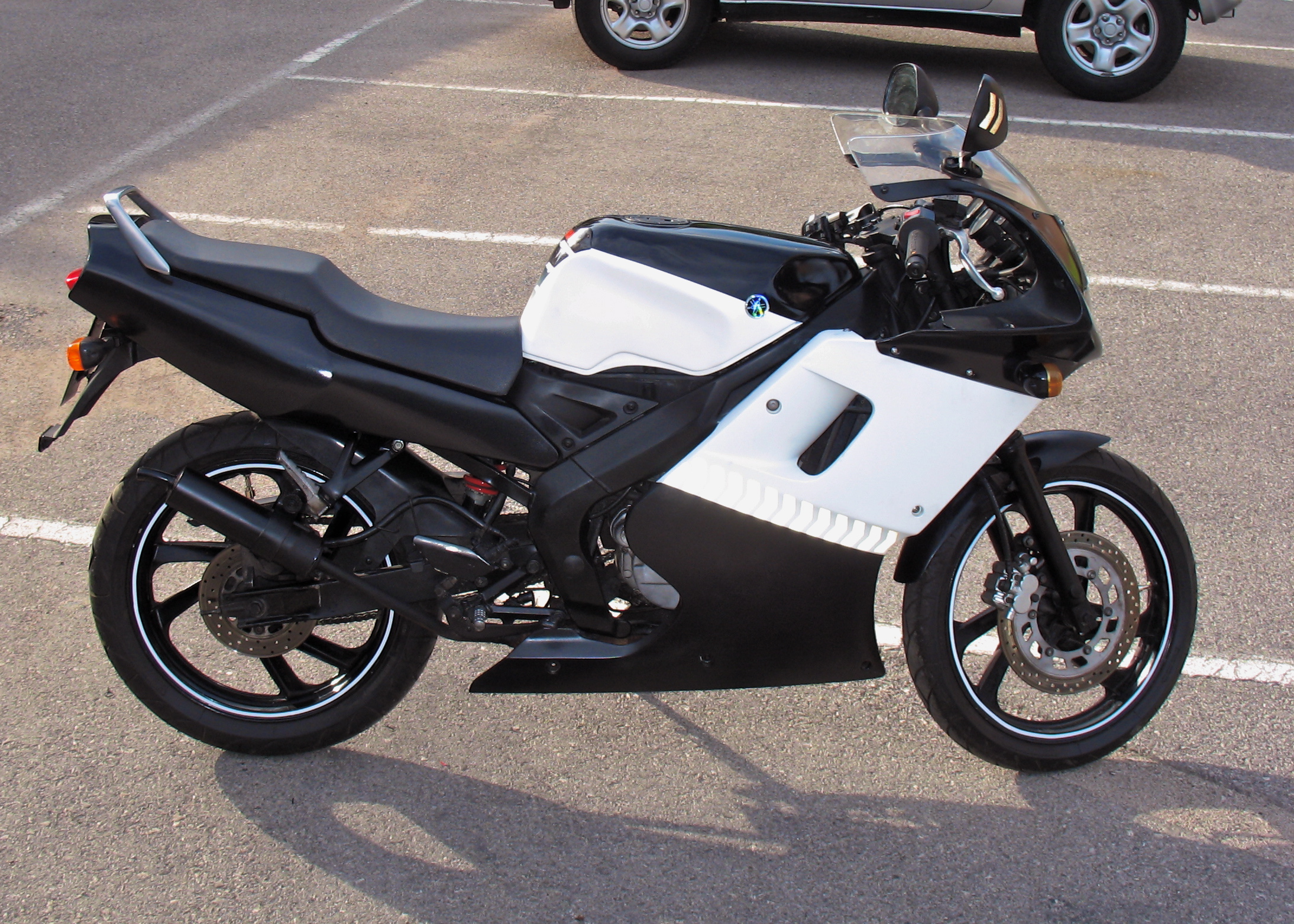 a black and white motorcycle parked in a parking space