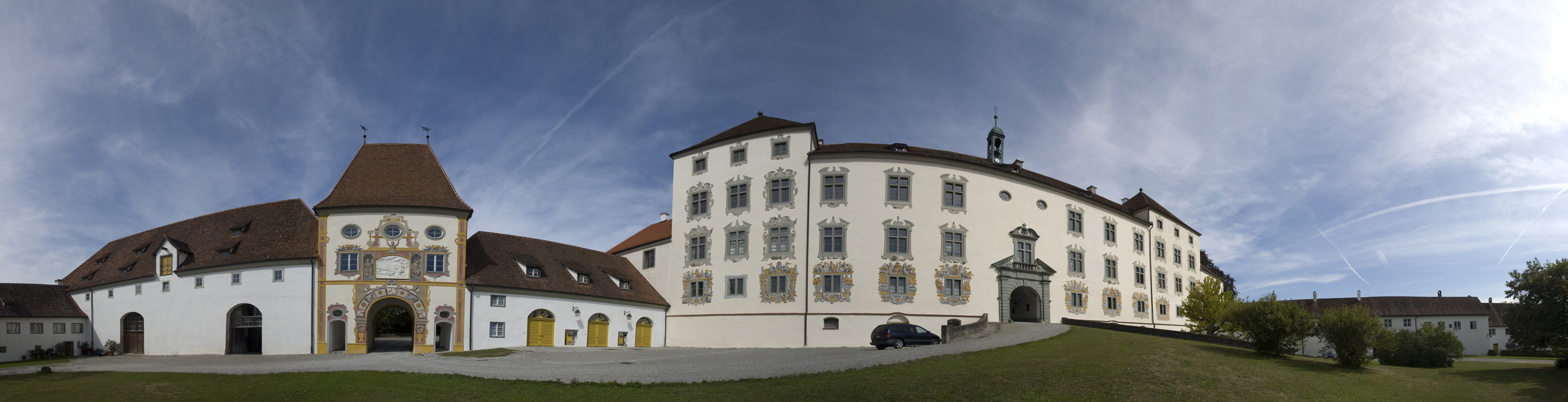 the large white building with several windows is sitting on the grass