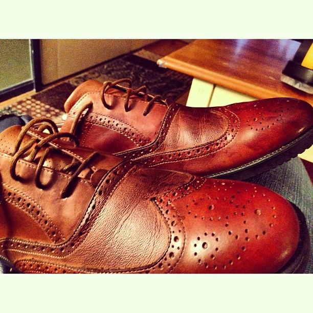 a pair of brown mens shoes on a table
