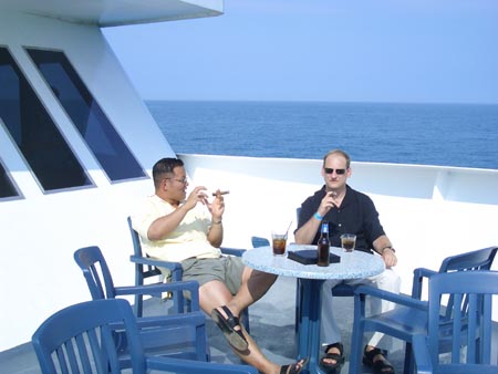 two men sitting at table on large boat