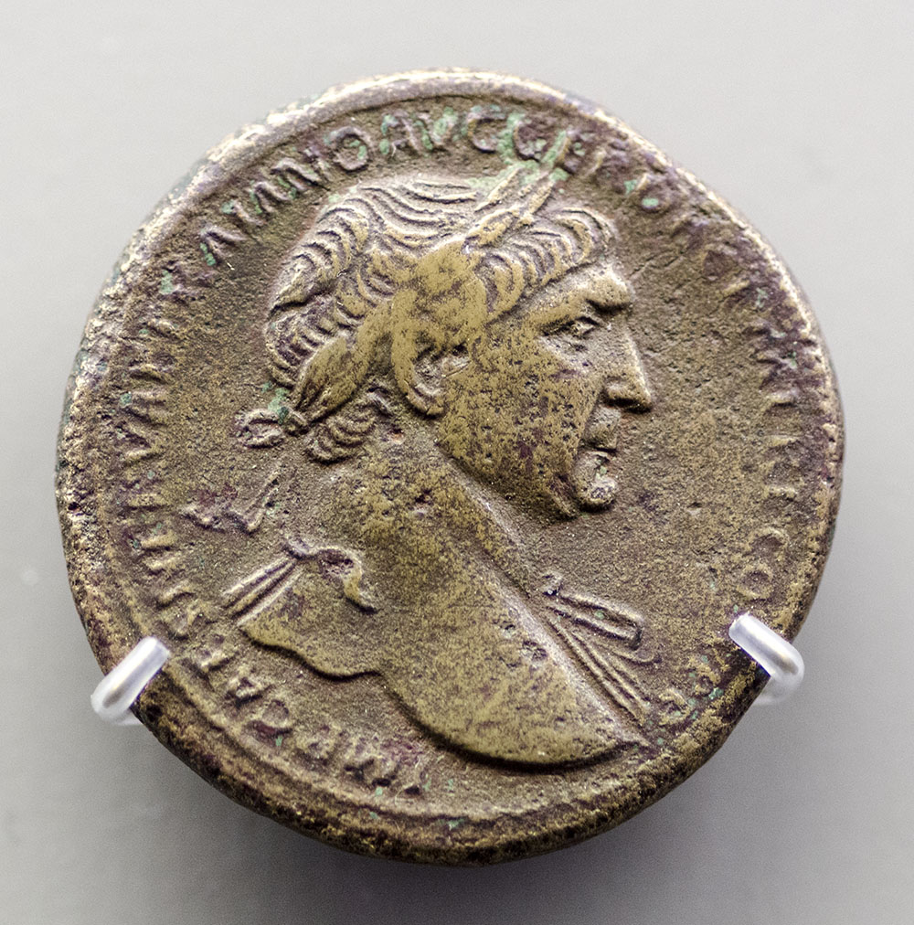 an old bronze roman coin with a woman face on it