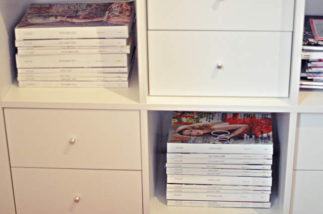 a stack of dvds and movies are on top of a white shelf