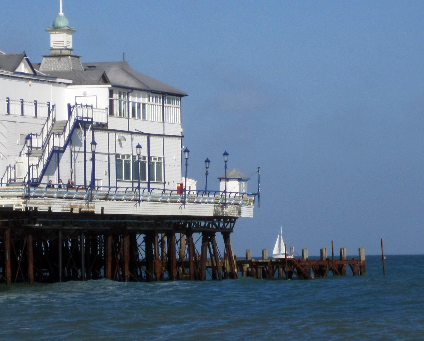 an old fashioned pier and its tower sticking out of the water