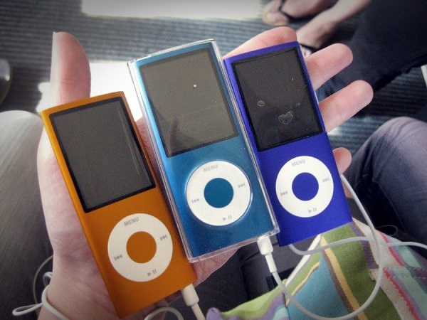 three different colored mp3 players in the palm of someone's hand