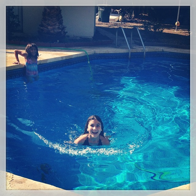 a little girl is swimming in the pool