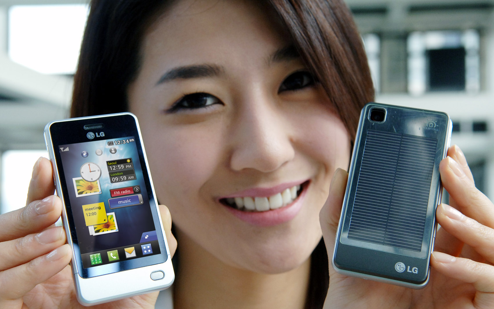 a woman smiling while holding two smart phones