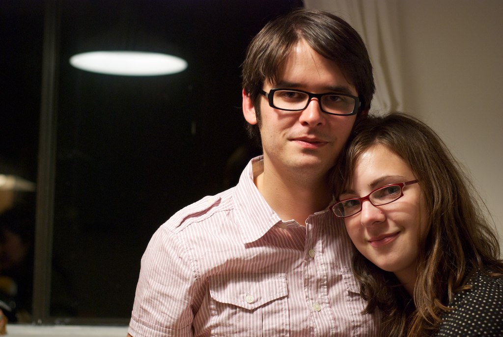 a close up of two people with one person wearing glasses