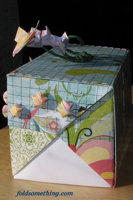 an origami style box has a bow around the side