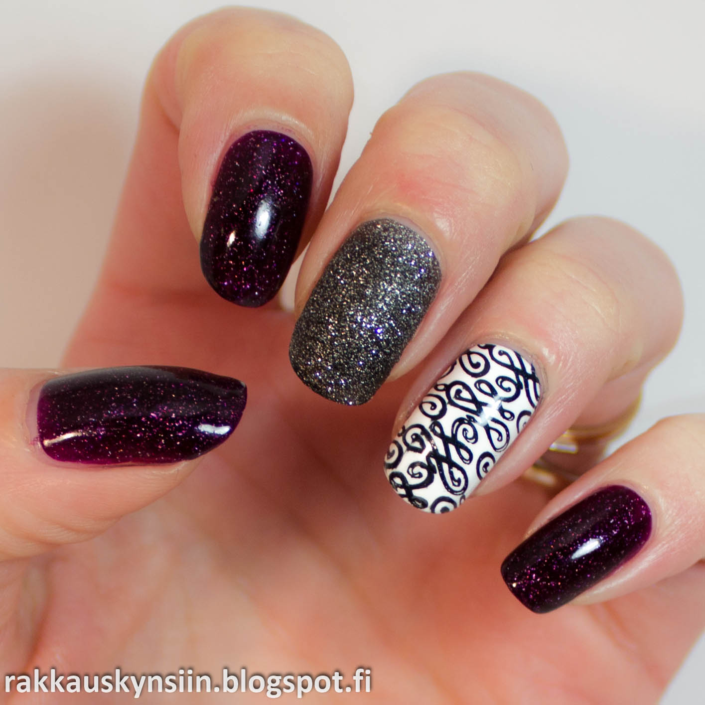 hand with a manicure with purple and white patterns