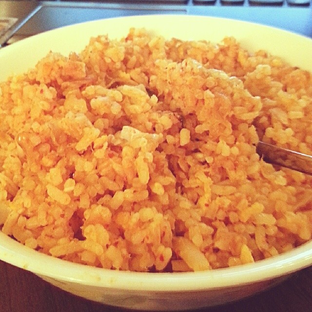 this is a bowl of cooked rice next to a laptop