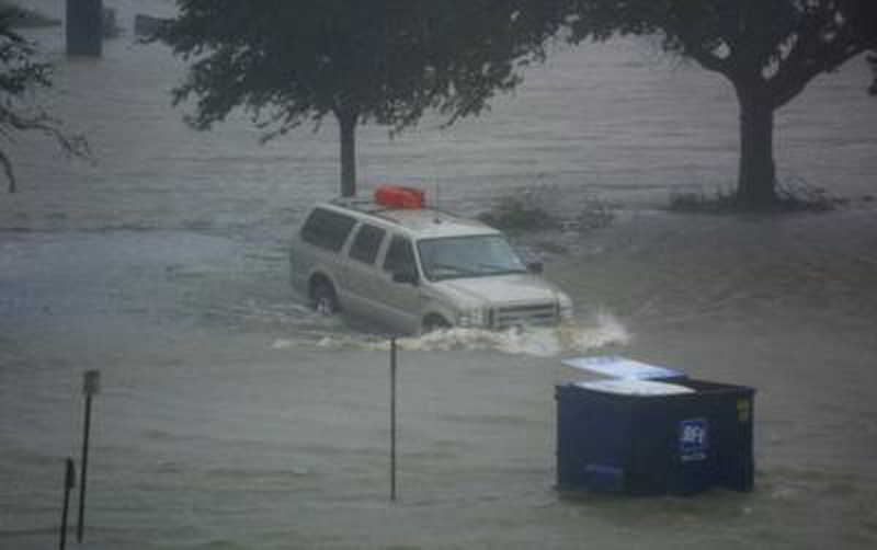 a van in a flooded area sitting under some trees