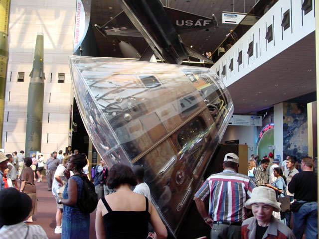 group of people standing around a very large piece of luggage