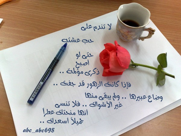 a rose and pen are placed on top of a sheet of paper