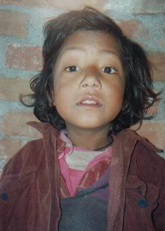 the young child looks into the camera while wearing a jacket