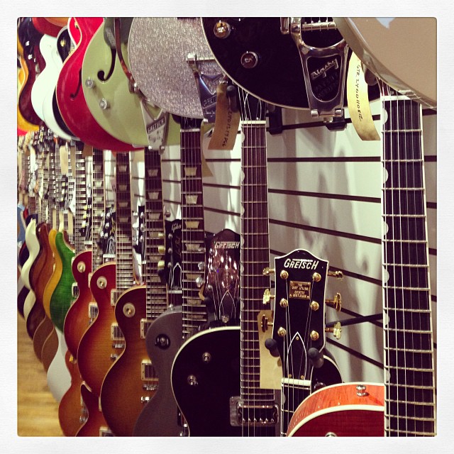 guitars are lined up on display in an office