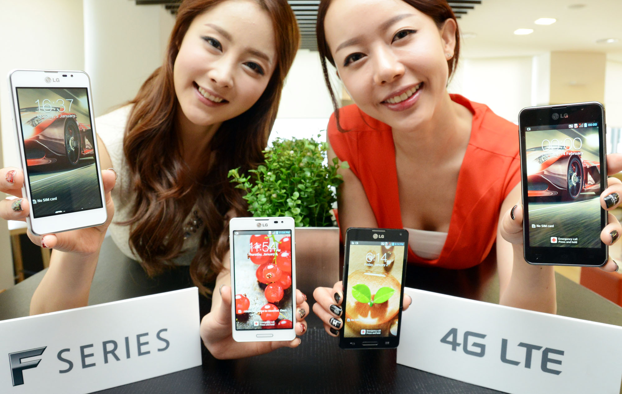 two woman holding cell phones displaying them for pos