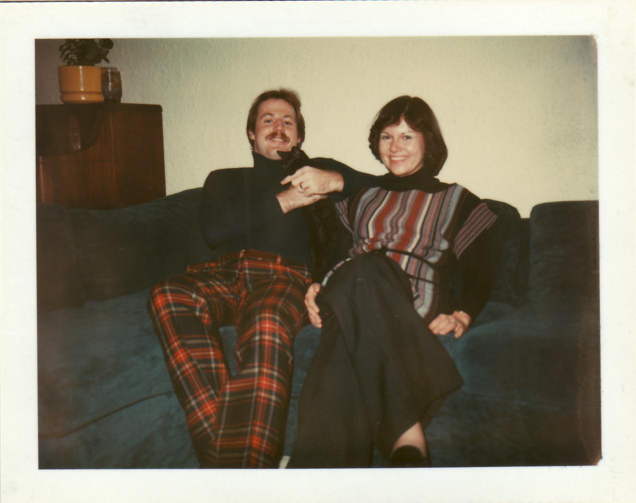 a man sitting next to a woman on top of a couch