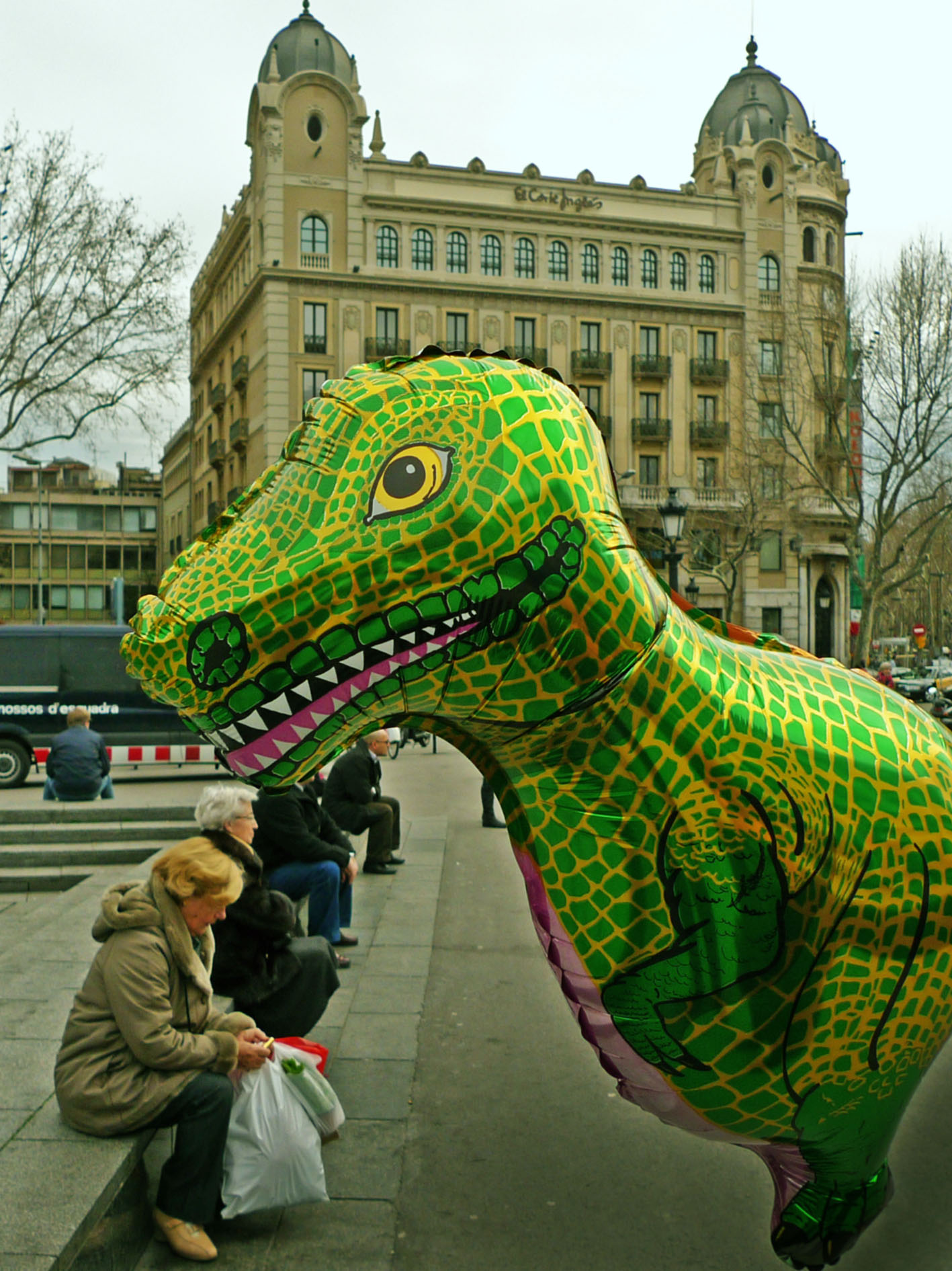 a huge dinosaur inflatable sitting in front of a crowd