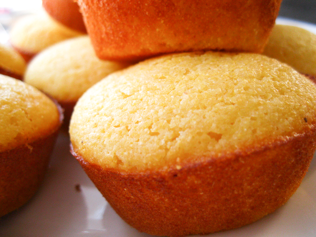 there is a white plate that has some yellow muffins on it