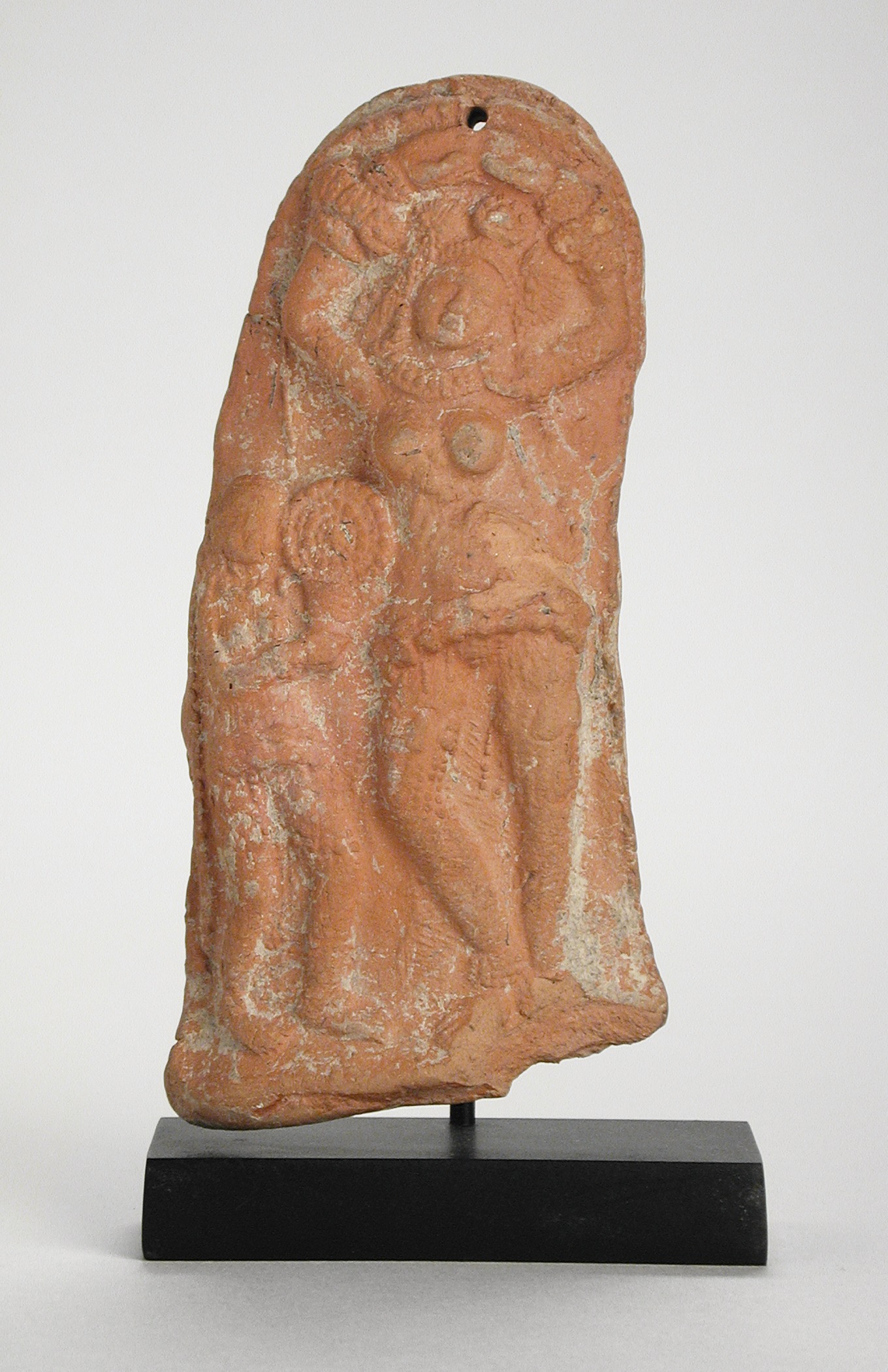 a brown stone statue with a face in the center