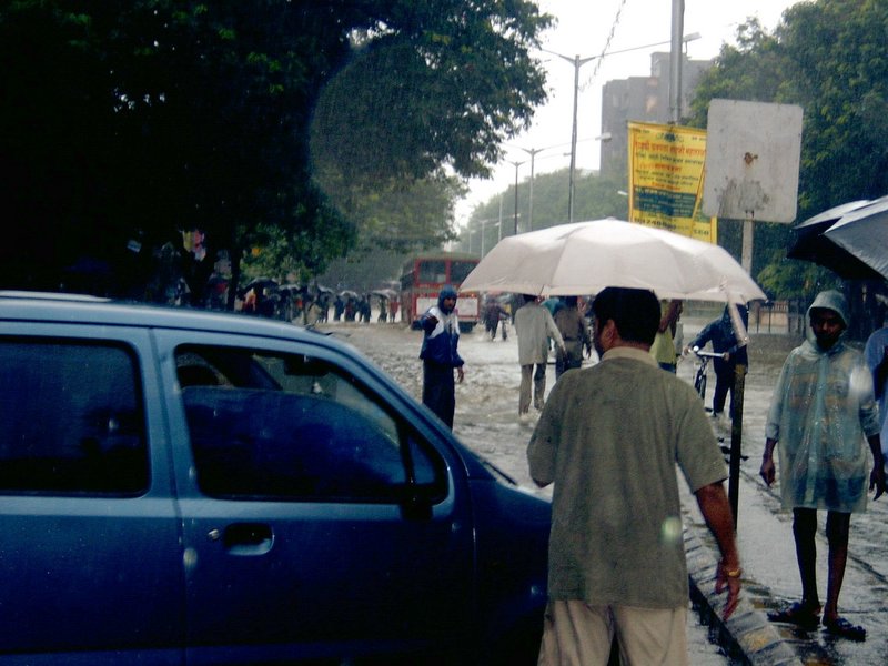 people walk in the street carrying umbrellas