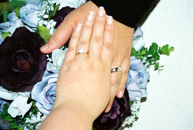 a bride and groom holding hands next to bouquet