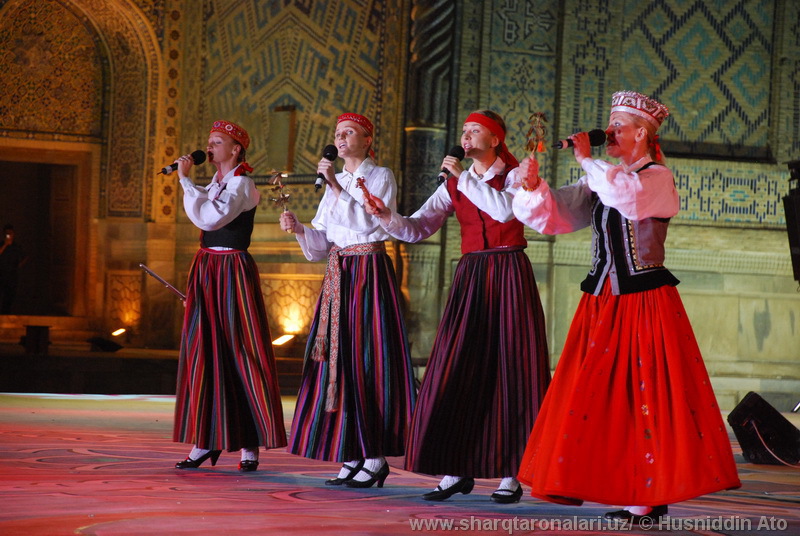 four girls standing next to each other on stage