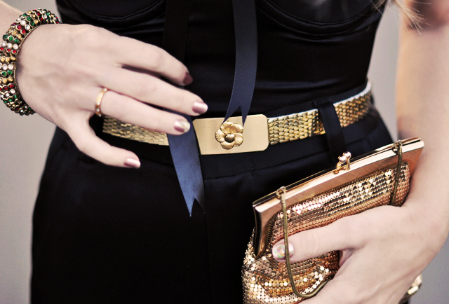 a woman holding a clutch and a gold purse