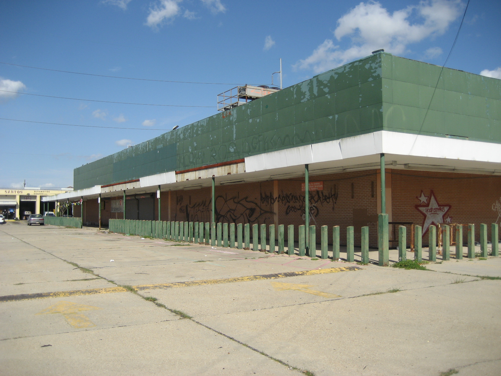 an empty lot next to a large green covered building
