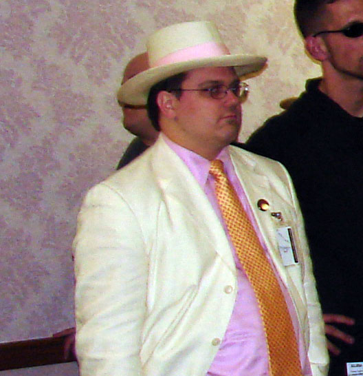 two men dressed up for a show, one wearing a white suit and the other in yellow tie