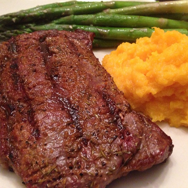 steak with green beans and mashed potatoes on a white plate