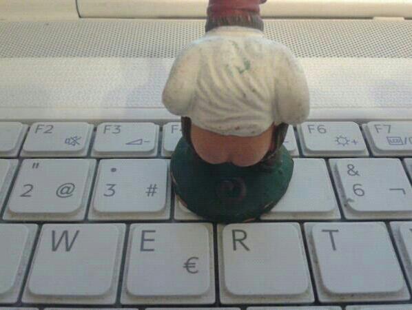 this figurine is sitting on top of a computer keyboard
