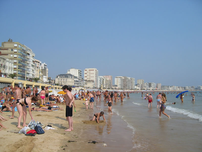 a crowd of people standing on top of a beach