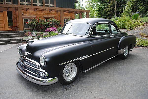 a black car parked in front of a house