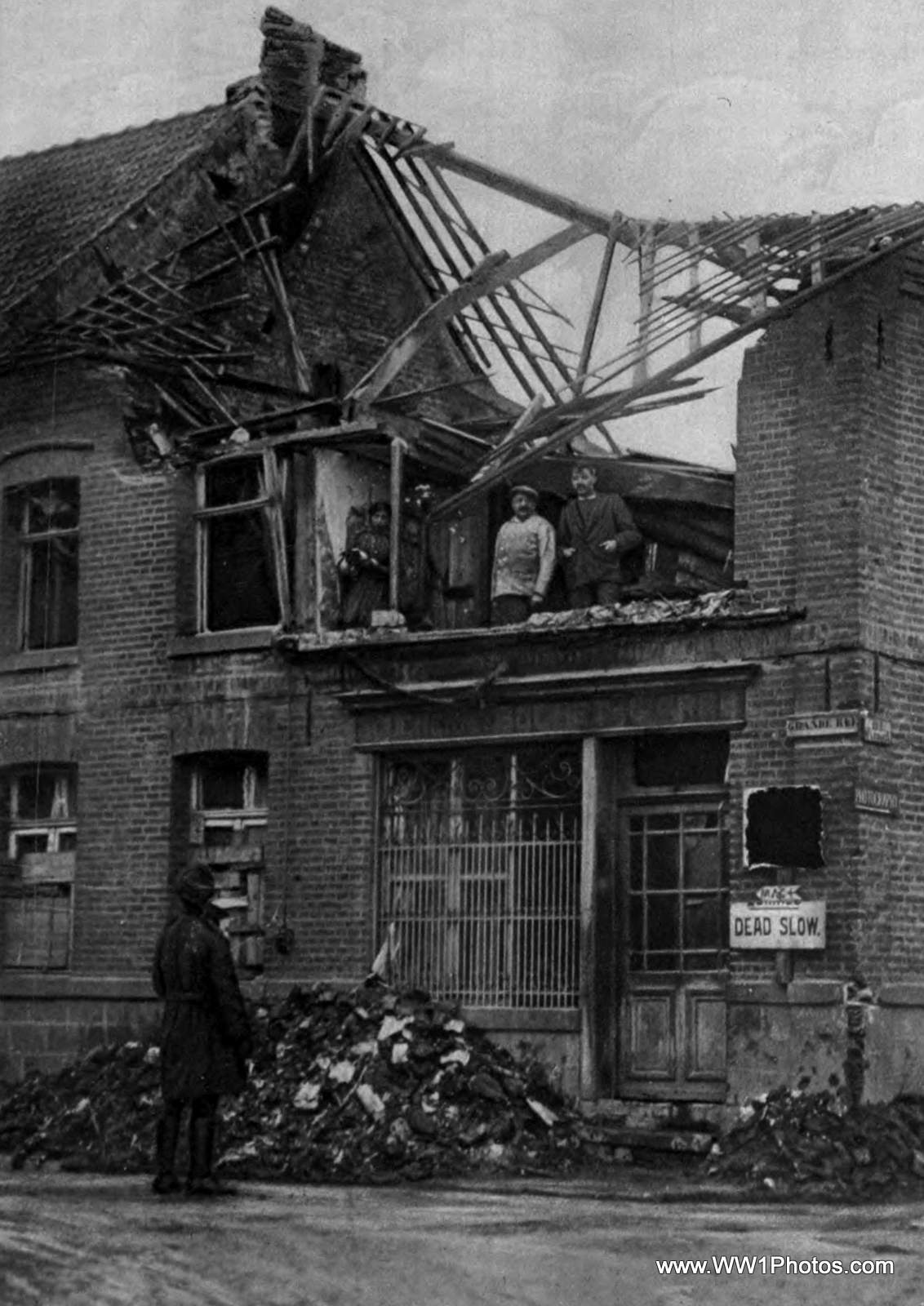 a destroyed down building has people outside and people inside