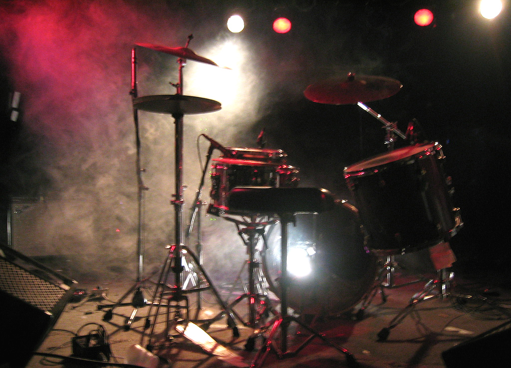 the drums on stage in front of bright colored lights