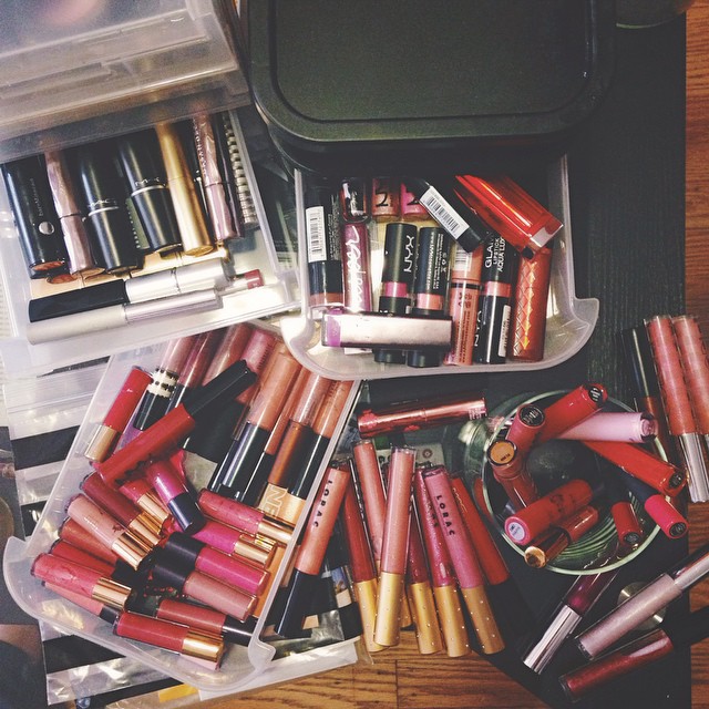 many lipsticks are displayed on a wooden table