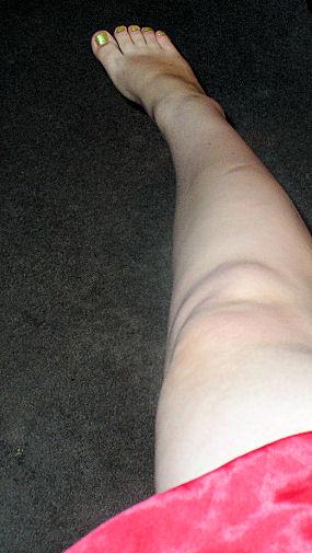 the back end of a womens bare legs on carpeted floor