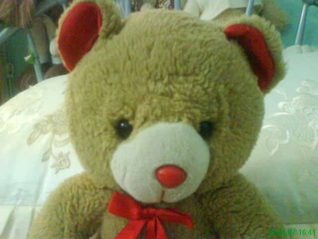 a stuffed bear with red nose and ears