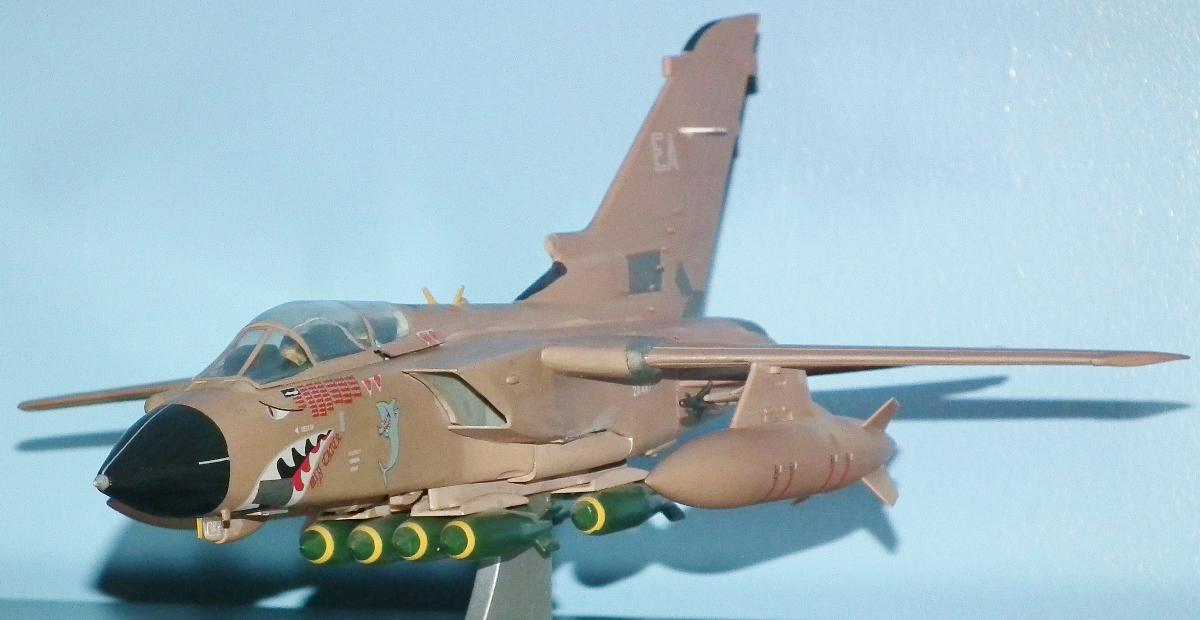 a model fighter jet on a stand near a wall