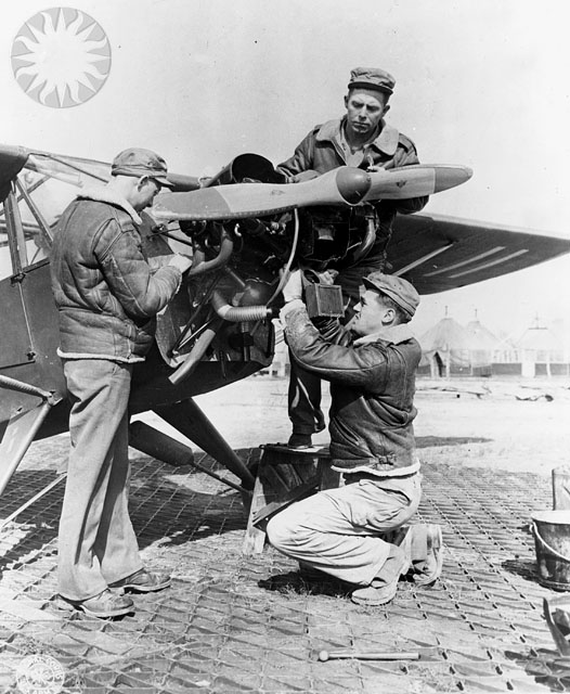 a group of men working on an old plane