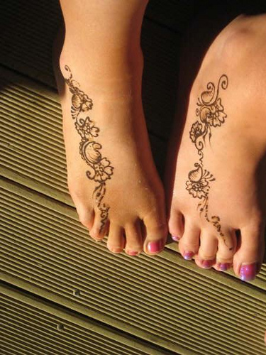 two feet with tattoo design on them