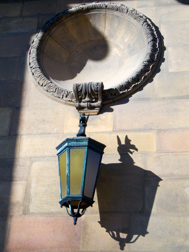 shadow of street lamp on the side of a wall