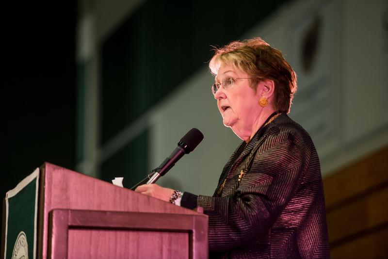 a woman speaking into a microphone at a podium