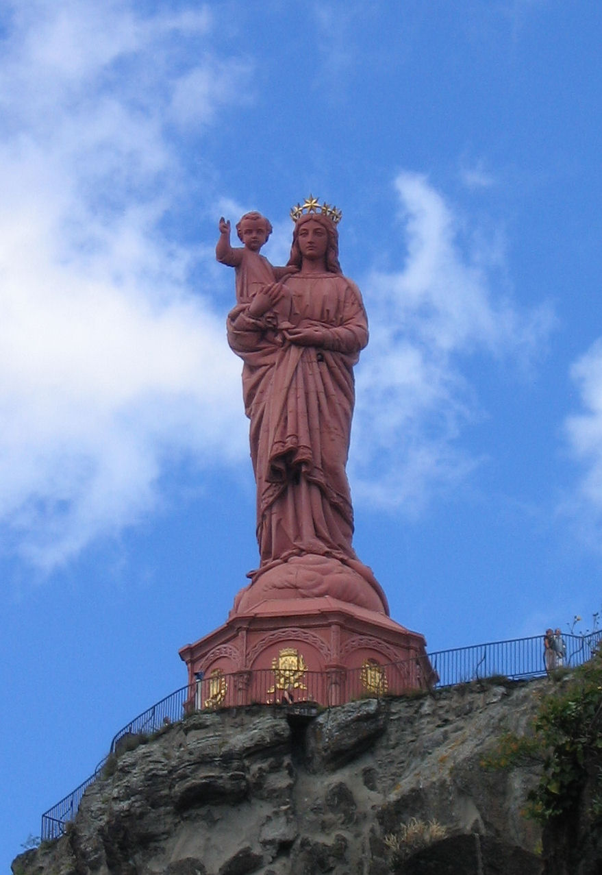 a statue of the statue of liberty atop a mountain