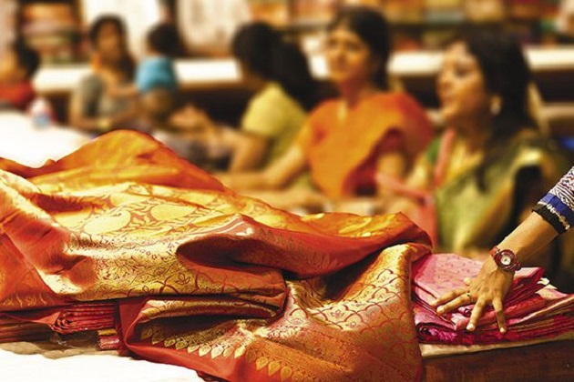 woman putting a pink and yellow colored sari on her lap