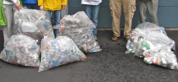 four people are standing together with bags of soda