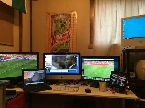 multiple computers and televisions on a desk