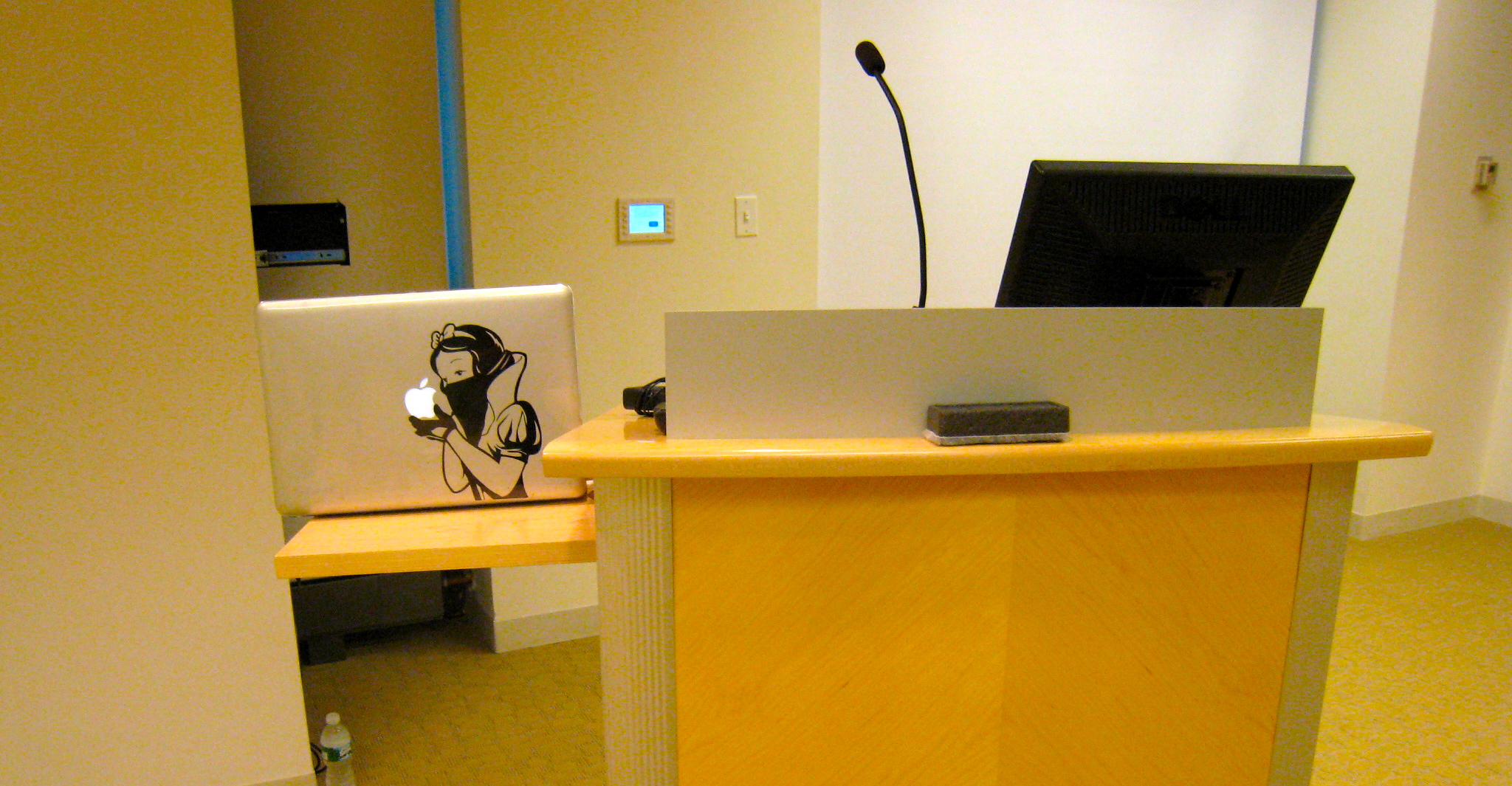 an empty work area with yellow table and computers